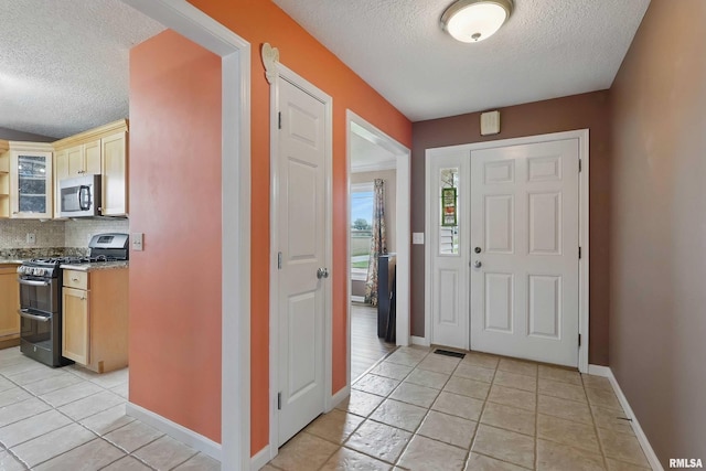 108 N Howard Ln, Long Grove, IA 52756 - foyer entrance with a textured ceiling, baseboards, and light tile patterned flooring