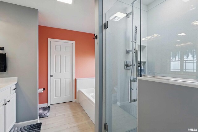 108 N Howard Ln, Long Grove, IA 52756 - bathroom with a garden tub, a stall shower, vanity, and wood finished floors