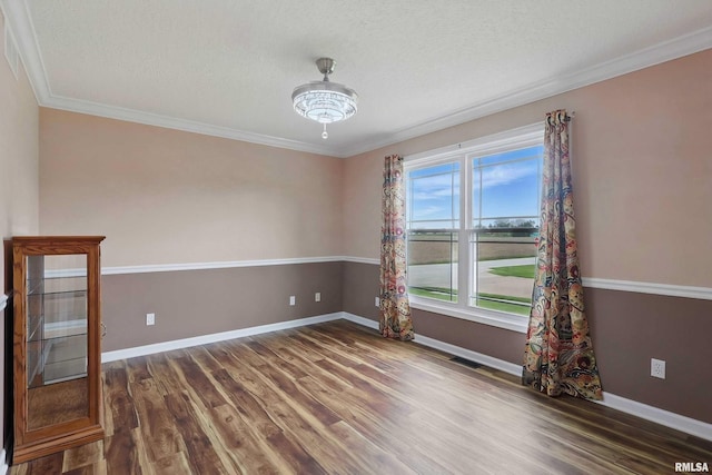 108 N Howard Ln, Long Grove, IA 52756 - empty room featuring wood finished floors, baseboards, crown molding, and a textured ceiling