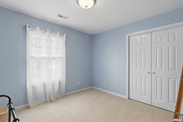 108 N Howard Ln, Long Grove, IA 52756 - unfurnished bedroom with carpet, baseboards, a textured ceiling, and a closet