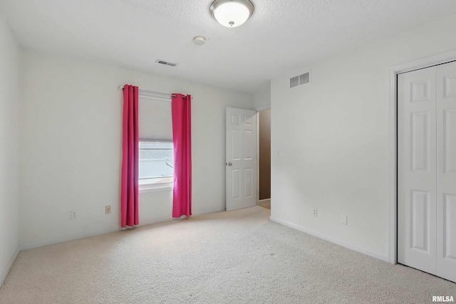 108 N Howard Ln, Long Grove, IA 52756 - unfurnished bedroom with carpet, baseboards, a textured ceiling, and a closet