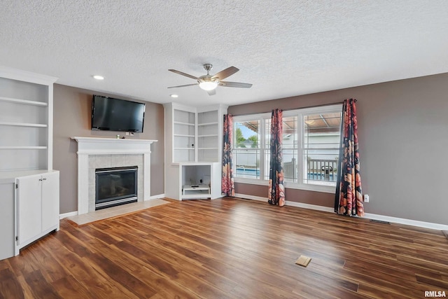 108 N Howard Ln, Long Grove, IA 52756 - unfurnished living room featuring a ceiling fan, wood finished floors, a fireplace, a textured ceiling, and baseboards