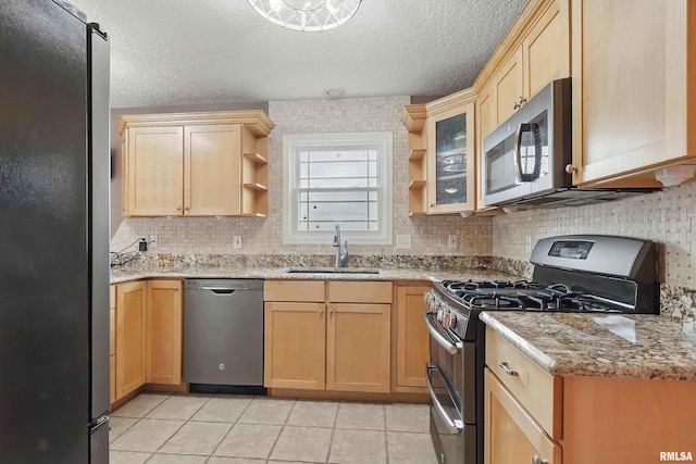 108 N Howard Ln, Long Grove, IA 52756 - kitchen with stainless steel appliances, a sink, open shelves, light tile patterned floors, and light brown cabinetry