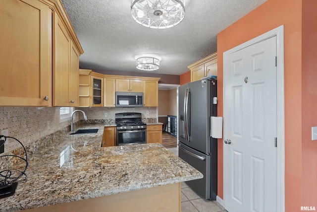108 N Howard Ln, Long Grove, IA 52756 - kitchen featuring appliances with stainless steel finishes, a sink, light brown cabinets, light stone countertops, and decorative backsplash