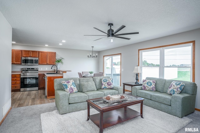 4260 Sapphire Ln, Bettendorf, IA 52722 - carpeted living area featuring recessed lighting, ceiling fan, a chandelier, a sink, and wood finished floors