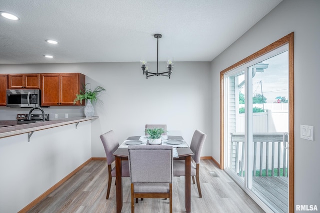 4260 Sapphire Ln, Bettendorf, IA 52722 - dining room featuring a chandelier, light wood-style floors, baseboards, recessed lighting, and a textured ceiling