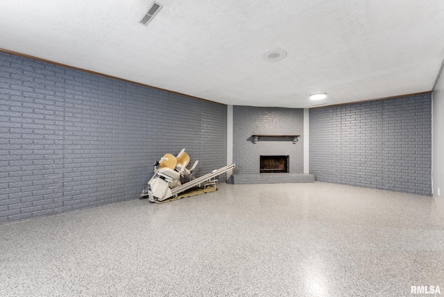 1409 10th Ave, Viola, IL 61486 - finished basement with a brick fireplace, a textured ceiling, and brick wall
