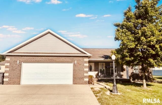 203 Breeze Dr, Carterville, IL 62918 - ranch-style house featuring brick siding, concrete driveway, an attached garage, and a front yard