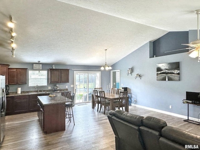 203 Breeze Dr, Carterville, IL 62918 - kitchen with a sink, wood finished floors, a kitchen island, a ceiling fan, and dark countertops