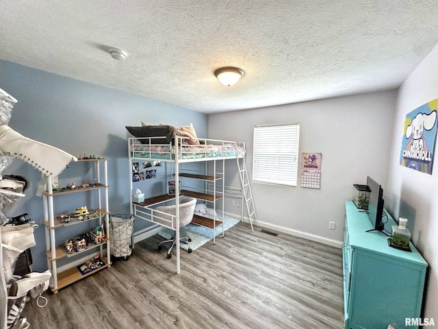 203 Breeze Dr, Carterville, IL 62918 - bedroom with wood finished floors, a textured ceiling, and baseboards