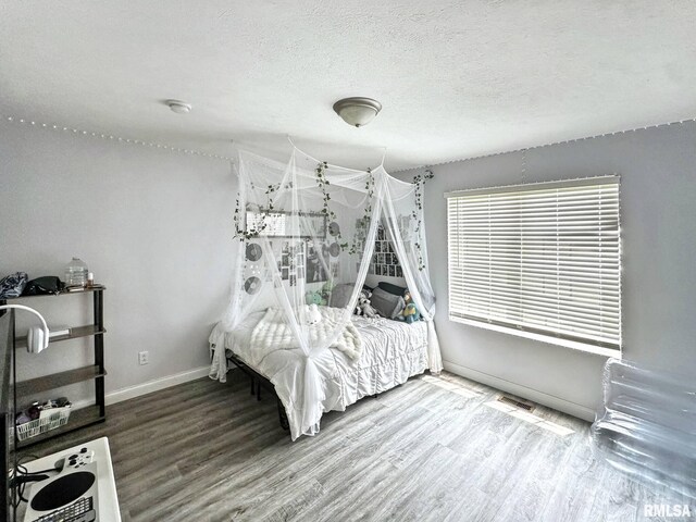 203 Breeze Dr, Carterville, IL 62918 - unfurnished bedroom featuring wood finished floors, baseboards, and a textured ceiling