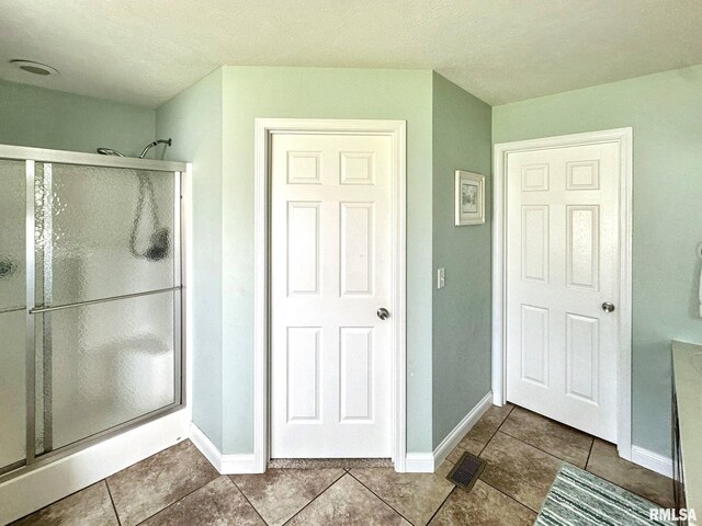 203 Breeze Dr, Carterville, IL 62918 - bathroom featuring a stall shower, baseboards, and tile patterned floors