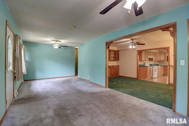 1148 Briarcliff Ln, Clinton, IA 52732 - unfurnished living room with a ceiling fan, light carpet, a textured ceiling, and baseboards