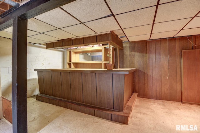 1148 Briarcliff Ln, Clinton, IA 52732 - indoor dry bar featuring tile patterned floors, a paneled ceiling, and wood walls