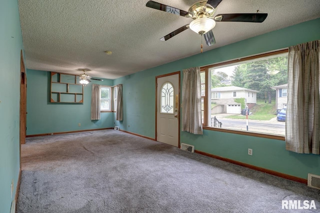 1148 Briarcliff Ln, Clinton, IA 52732 - foyer entrance featuring a ceiling fan, a textured ceiling, carpet, and baseboards