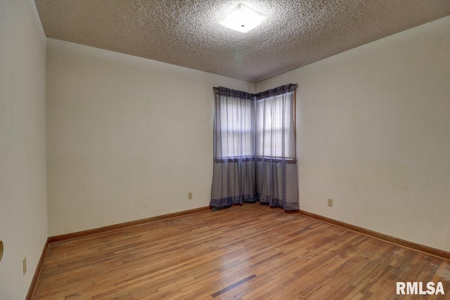 1148 Briarcliff Ln, Clinton, IA 52732 - unfurnished room with wood finished floors, a textured ceiling, and baseboards