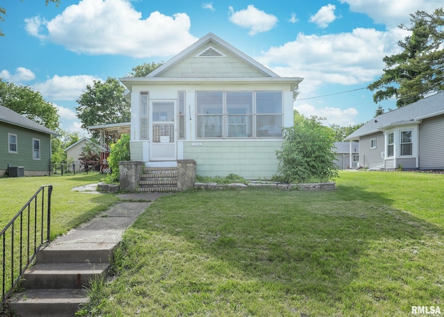 1036 30th St, Rock Island, IL 61201 - view of front of house featuring central air condition unit, a front lawn, and a sunroom
