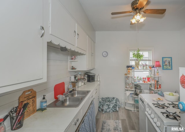 1036 30th St, Rock Island, IL 61201 - kitchen featuring a sink, light countertops, light wood-type flooring, ceiling fan, and white cabinetry