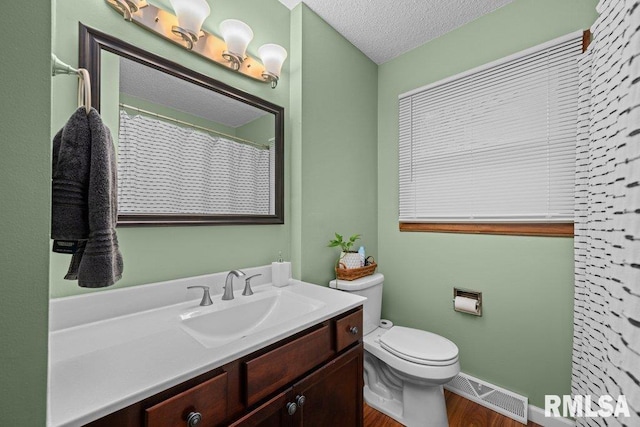 237 Colony Dr, Davenport, IA 52806 - full bath with vanity, wood finished floors, toilet, a textured ceiling, and baseboards