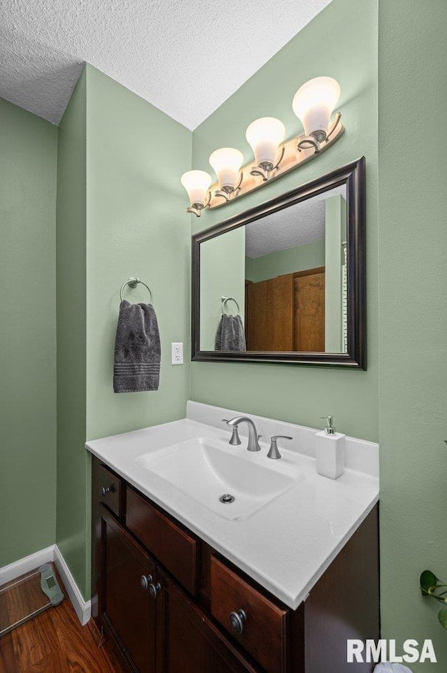 237 Colony Dr, Davenport, IA 52806 - bathroom featuring vanity, wood finished floors, a textured ceiling, and baseboards