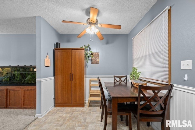 237 Colony Dr, Davenport, IA 52806 - dining room featuring wainscoting, a textured ceiling, and ceiling fan