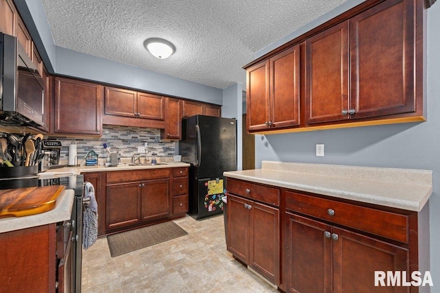 237 Colony Dr, Davenport, IA 52806 - kitchen with freestanding refrigerator, stainless steel gas stove, decorative backsplash, light countertops, and a textured ceiling