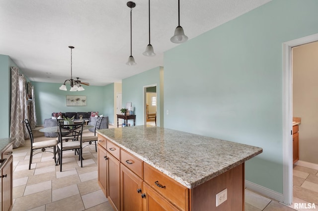 5817 Woodland Ave, Davenport, IA 52807 - kitchen featuring a center island, open floor plan, pendant lighting, and light stone counters