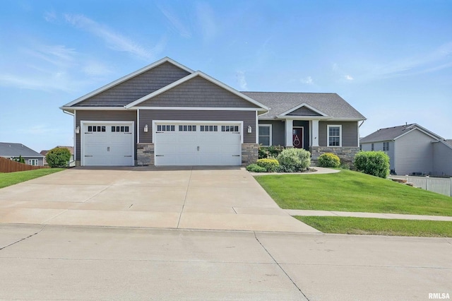 4241 Colorado Dr, Bettendorf, IA 52722 - craftsman-style home featuring a garage, a front yard, driveway, and stone siding