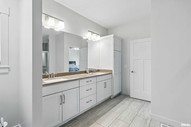 4241 Colorado Dr, Bettendorf, IA 52722 - bathroom featuring double vanity, baseboards, and ensuite bathroom