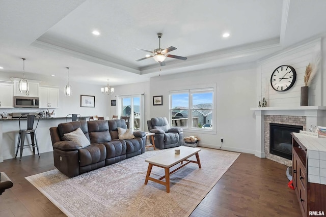 4241 Colorado Dr, Bettendorf, IA 52722 - living area with a raised ceiling, a ceiling fan, recessed lighting, dark wood-style flooring, and a brick fireplace