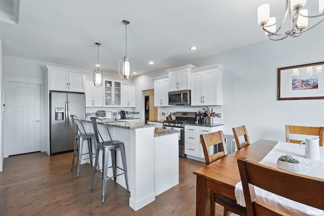 4241 Colorado Dr, Bettendorf, IA 52722 - kitchen with stainless steel appliances, dark wood finished floors, decorative backsplash, glass insert cabinets, and white cabinetry