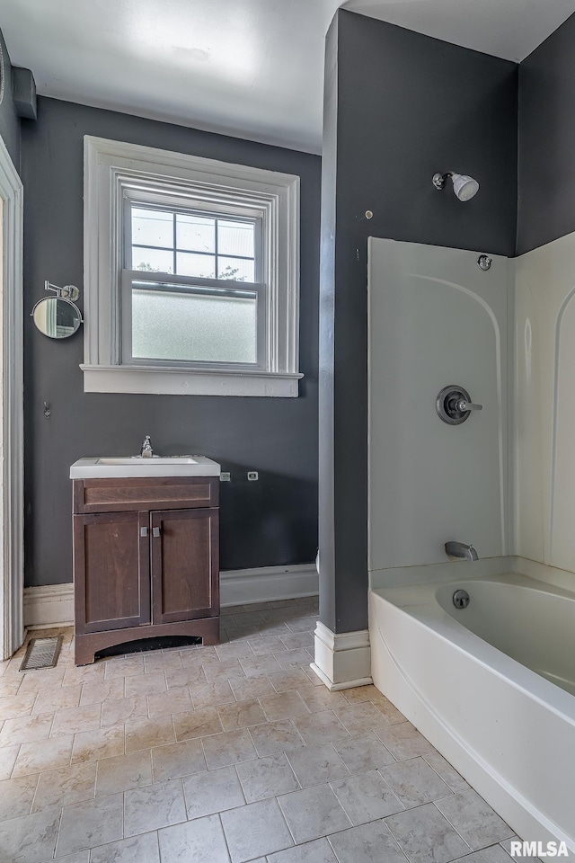 1415 Pershing Ave, Davenport, IA 52803 - bathroom featuring vanity, shower / bathtub combination, and baseboards