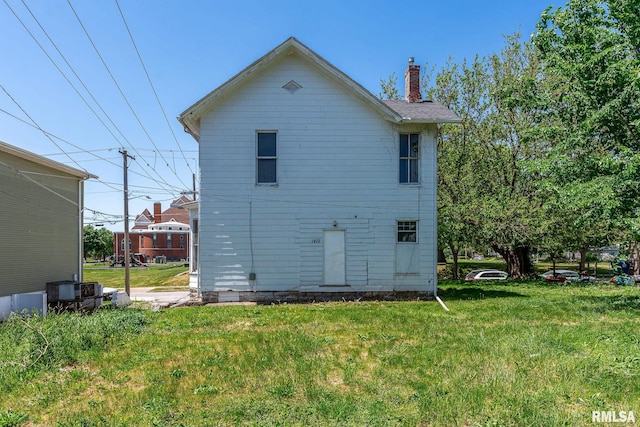 1415 Pershing Ave, Davenport, IA 52803 - back of property featuring a chimney and a yard