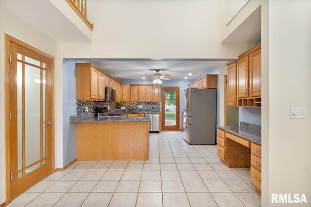 859 45th Ave, East Moline, IL 61244 - kitchen featuring appliances with stainless steel finishes, decorative backsplash, ceiling fan, a peninsula, and light tile patterned floors