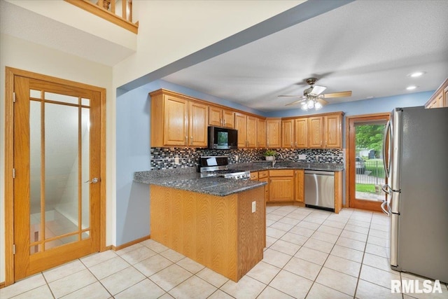 859 45th Ave, East Moline, IL 61244 - kitchen with appliances with stainless steel finishes, a peninsula, decorative backsplash, a sink, and a ceiling fan