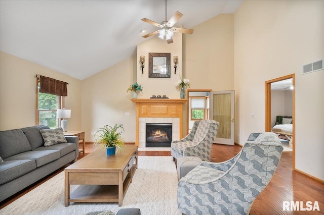 859 45th Ave, East Moline, IL 61244 - living area featuring high vaulted ceiling, ceiling fan, a tiled fireplace, light wood-style floors, and baseboards