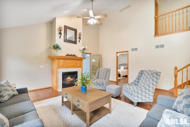 859 45th Ave, East Moline, IL 61244 - living room featuring wood finished floors, high vaulted ceiling, a fireplace, a ceiling fan, and baseboards