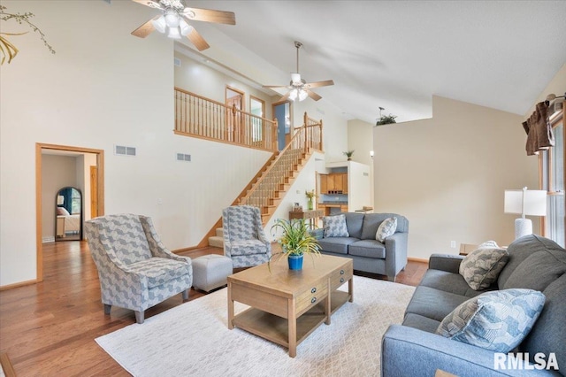 859 45th Ave, East Moline, IL 61244 - living area with high vaulted ceiling, a ceiling fan, wood finished floors, stairs, and baseboards