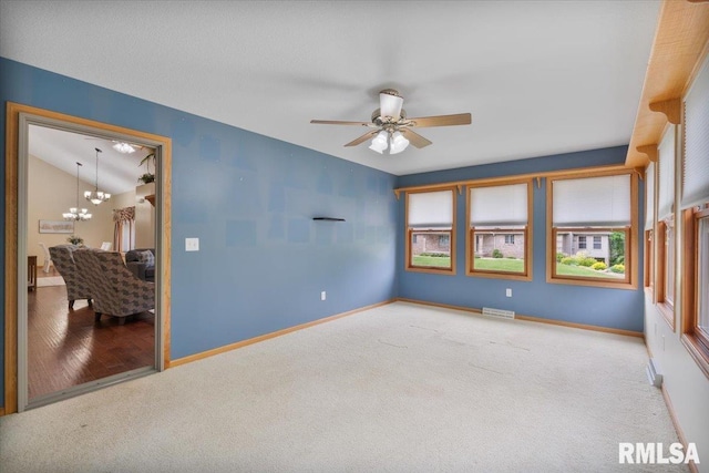 859 45th Ave, East Moline, IL 61244 - carpeted empty room featuring plenty of natural light, a chandelier, a ceiling fan, baseboards, and lofted ceiling