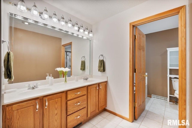 859 45th Ave, East Moline, IL 61244 - full bathroom with double vanity, tile patterned floors, toilet, and baseboards