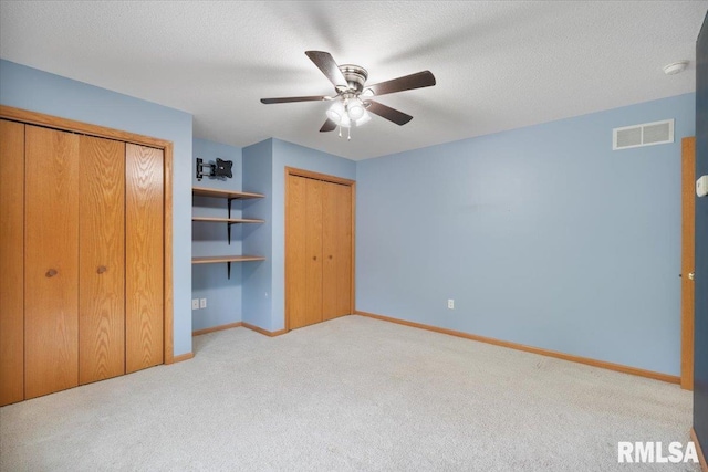 859 45th Ave, East Moline, IL 61244 - unfurnished bedroom with light colored carpet, baseboards, a ceiling fan, and a textured ceiling