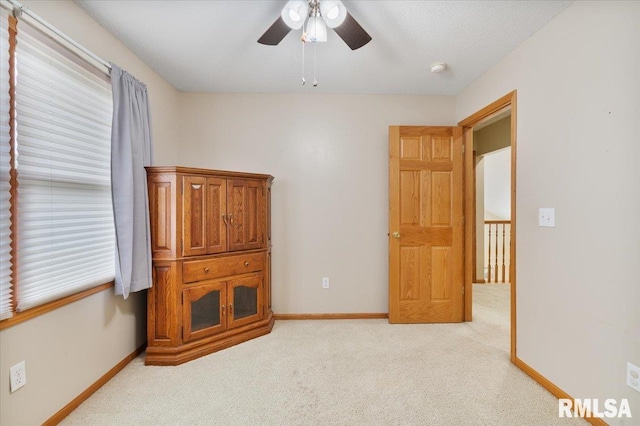 859 45th Ave, East Moline, IL 61244 - unfurnished bedroom with light colored carpet, baseboards, and a ceiling fan