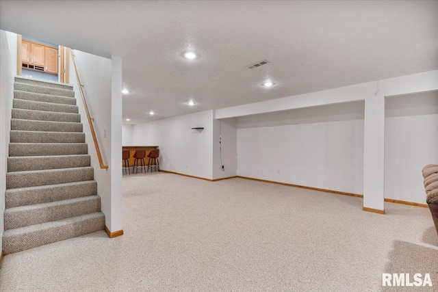 859 45th Ave, East Moline, IL 61244 - finished below grade area with light carpet, stairway, baseboards, recessed lighting, and bar area