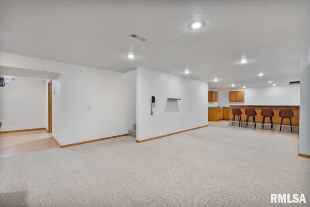 859 45th Ave, East Moline, IL 61244 - finished below grade area with light carpet, bar area, baseboards, recessed lighting, and a textured ceiling