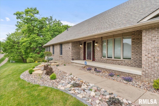 859 45th Ave, East Moline, IL 61244 - property entrance with brick siding, roof with shingles, a lawn, and covered porch
