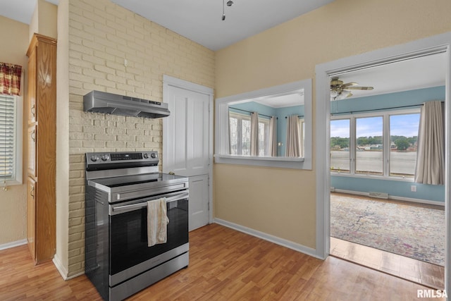 608 S Main St, Port Byron, IL 61275 - kitchen with stainless steel range with electric cooktop, extractor fan, a ceiling fan, wood finished floors, and plenty of natural light
