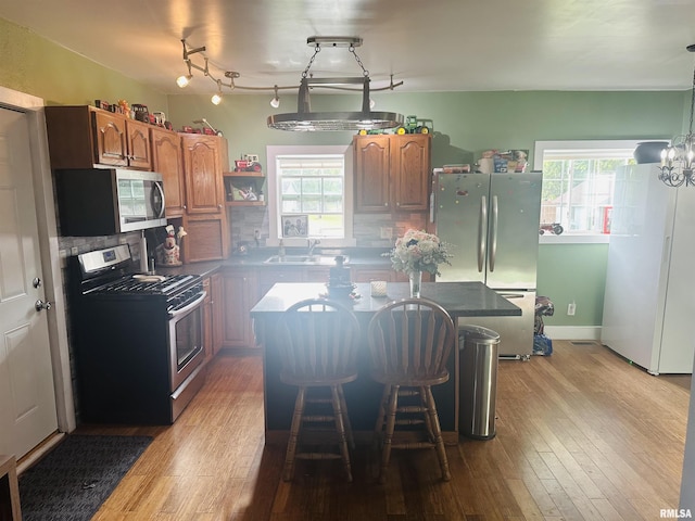 119 S Elm St, Williamsfield, IL 61489 - kitchen featuring appliances with stainless steel finishes, a sink, a center island, light wood-style floors, and decorative backsplash