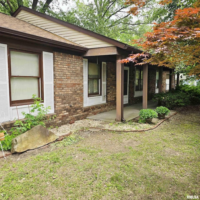 414 S Clayton St, Benton, IL 62812 - view of home's exterior with brick siding, a patio area, and a yard