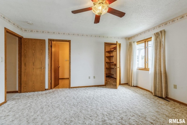 404 10th St, Lowden, IA 52255 - unfurnished bedroom with baseboards, carpet floors, a textured ceiling, ensuite bath, and a spacious closet