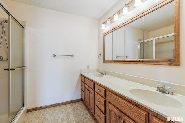 404 10th St, Lowden, IA 52255 - full bathroom featuring a shower with door, double vanity, and baseboards